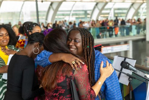 Barby Asante embracing Shirin Razavian, one of the TfL performers following their performance at Stratford station, 17 September 2023. Photo: Benedict Johnson